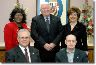 seated left to right: Commissioner President Wayne Cooper, Commissioner Robert Fuller. Standing left to right: Commissioner Edith Patterson, Commissioner Al Smith, Commissioner Candice Kelly